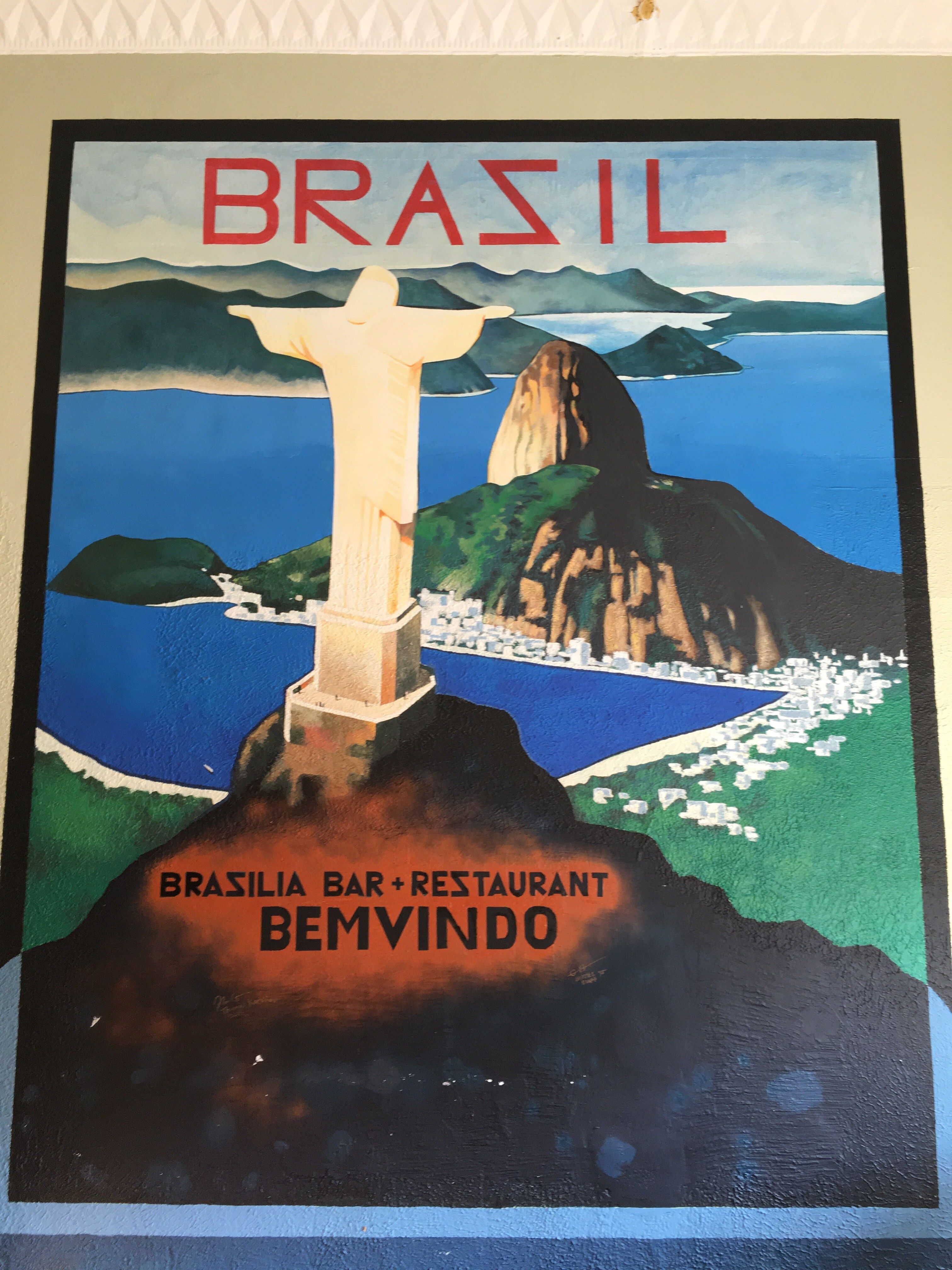 A painted mural of Rio de Janeiro inside Brasilia, showing Christ the Redeemer, Sugarloaf Mountain, the ocean, and lettering that reads BRASIL and BRASILIA BAR + RESTAURANT.